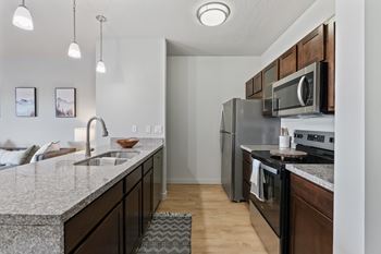 A kitchen with a granite countertop and stainless steel appliances.